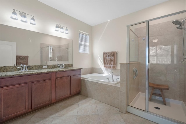 bathroom with a stall shower, tile patterned flooring, a garden tub, and a sink