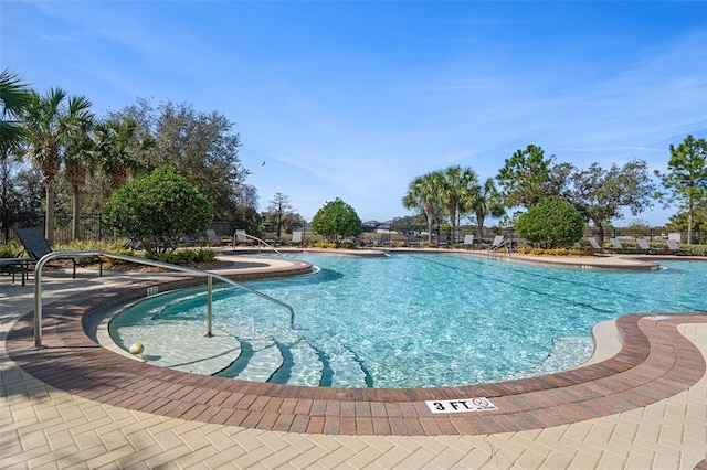 pool with a patio area and fence