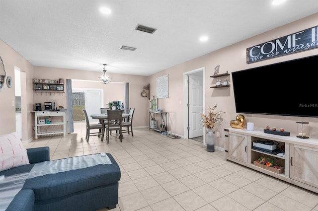 tiled living room featuring a textured ceiling