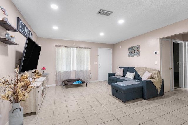 living room featuring a textured ceiling and light tile patterned floors