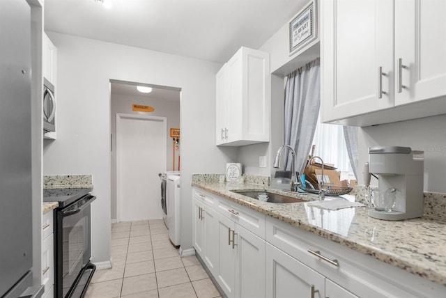 kitchen with white cabinetry, black electric range oven, washer and clothes dryer, and sink