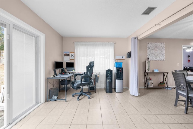 home office with light tile patterned floors and a wealth of natural light