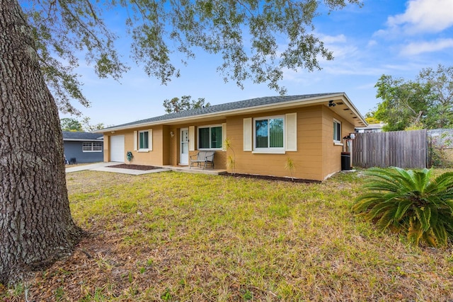 back of house with a lawn and a garage