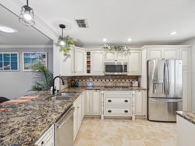 kitchen featuring pendant lighting, sink, appliances with stainless steel finishes, decorative backsplash, and dark stone counters