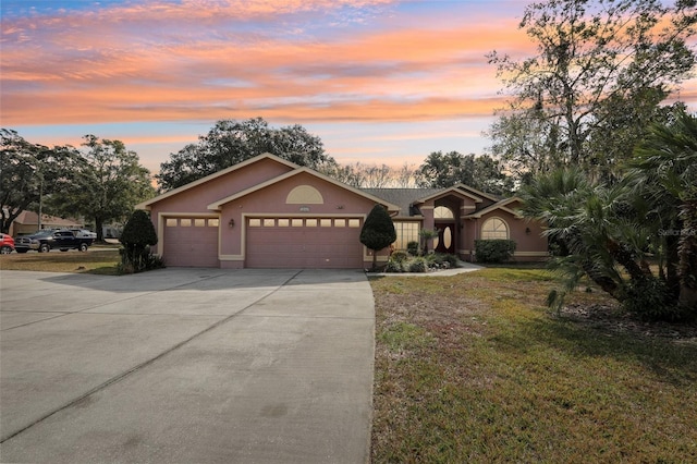 ranch-style home featuring a yard and a garage