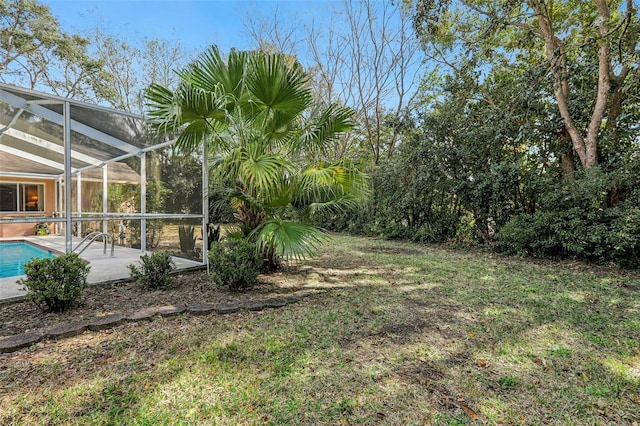 view of yard featuring glass enclosure and a patio