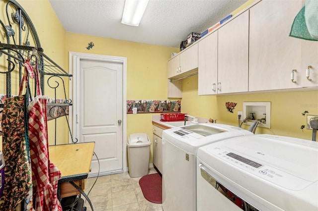 washroom featuring sink, independent washer and dryer, a textured ceiling, and cabinets