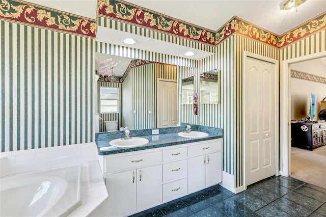 bathroom featuring a bath, a textured ceiling, and vanity