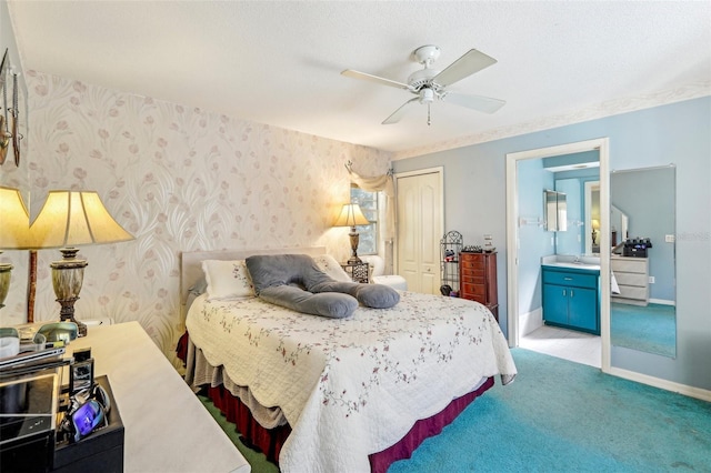 carpeted bedroom with ceiling fan, ensuite bath, a closet, and a textured ceiling