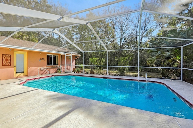 view of swimming pool featuring glass enclosure and a patio