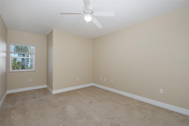 carpeted spare room featuring ceiling fan