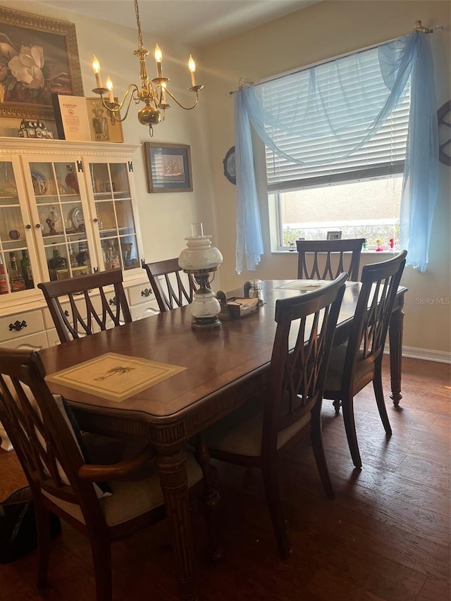 dining space with a chandelier and dark hardwood / wood-style flooring