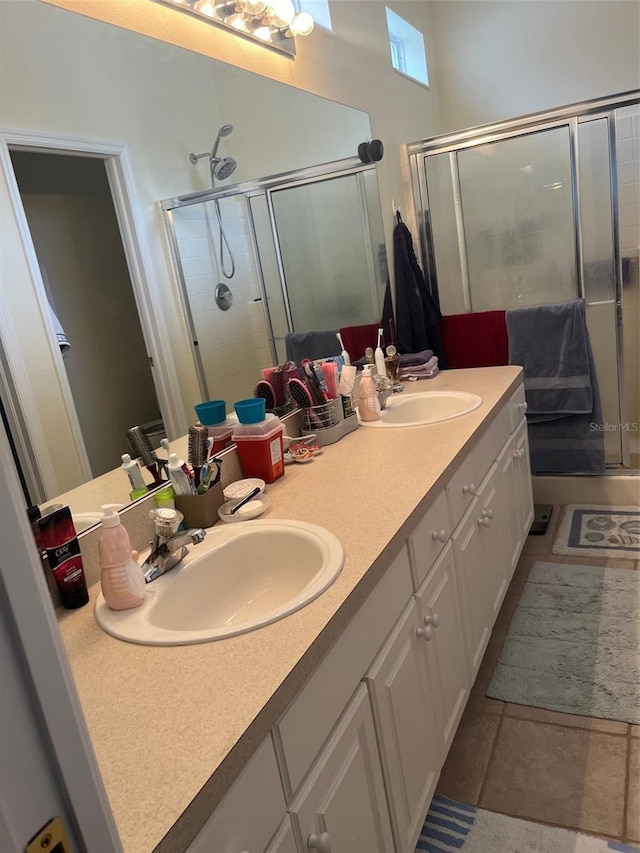 bathroom with a shower with shower door, tile patterned floors, and vanity