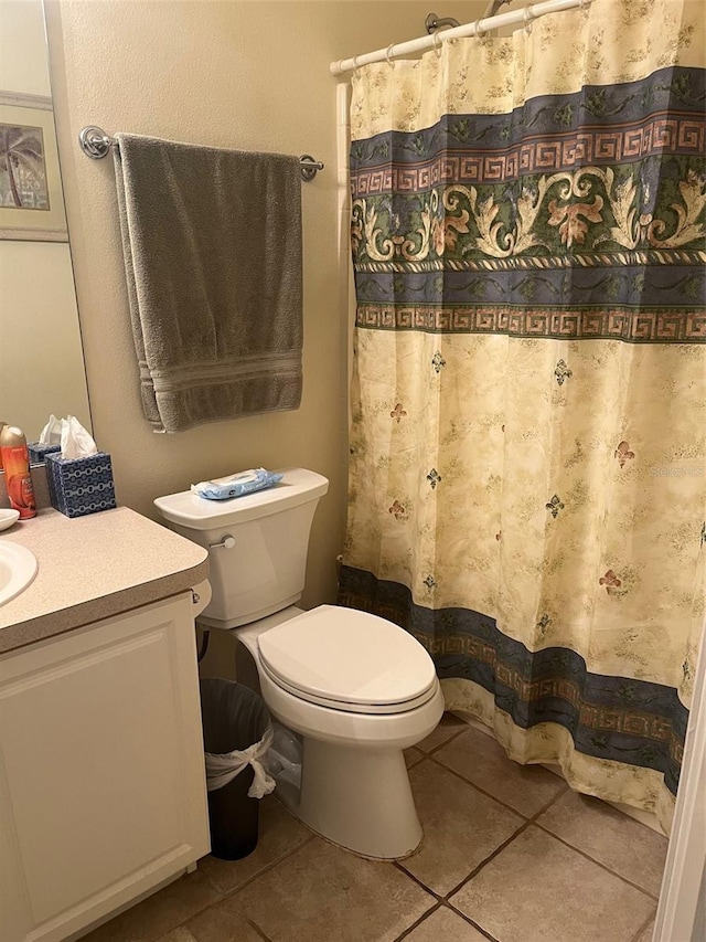 bathroom featuring toilet, tile patterned floors, vanity, and curtained shower