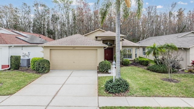 ranch-style home with a garage, central AC, driveway, stucco siding, and a front lawn