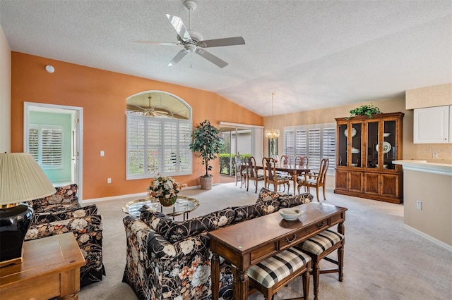 living room with light carpet, baseboards, ceiling fan, vaulted ceiling, and a textured ceiling