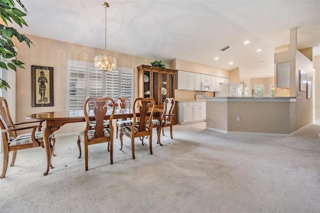 dining space with recessed lighting, light colored carpet, visible vents, an inviting chandelier, and baseboards