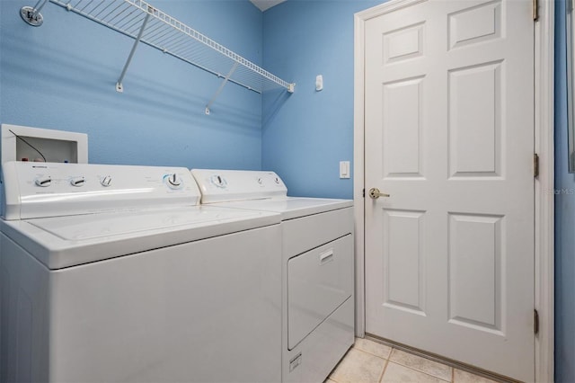 washroom with laundry area, washing machine and clothes dryer, and light tile patterned floors