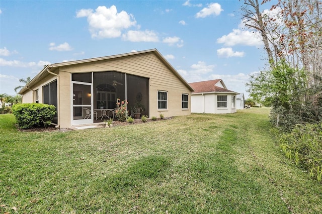 rear view of property with a lawn and a sunroom