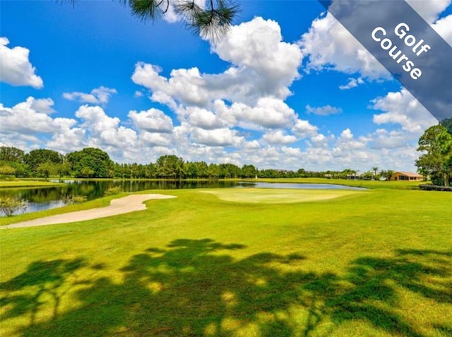 view of community featuring a water view, view of golf course, and a lawn