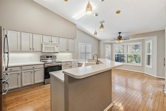 kitchen featuring light wood finished floors, visible vents, light countertops, stainless steel appliances, and a sink