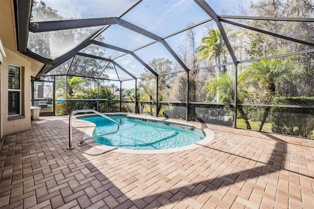 outdoor pool with glass enclosure and a patio area