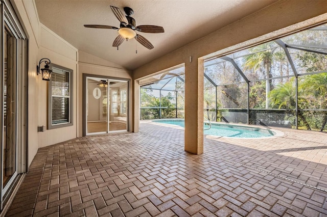 unfurnished sunroom with a pool, a ceiling fan, and lofted ceiling