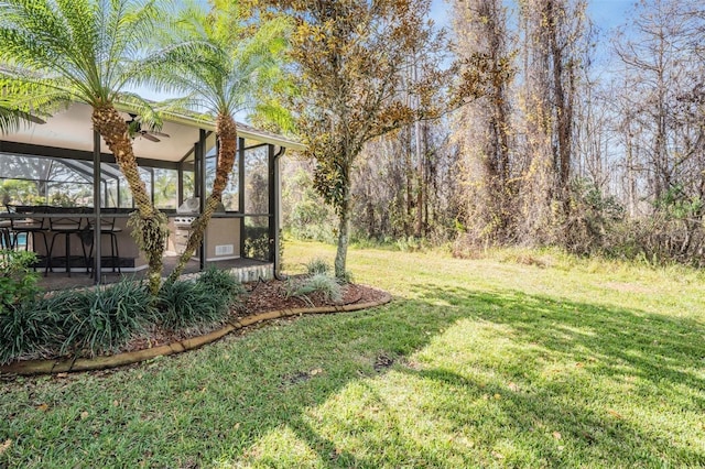 view of yard with glass enclosure and a patio area