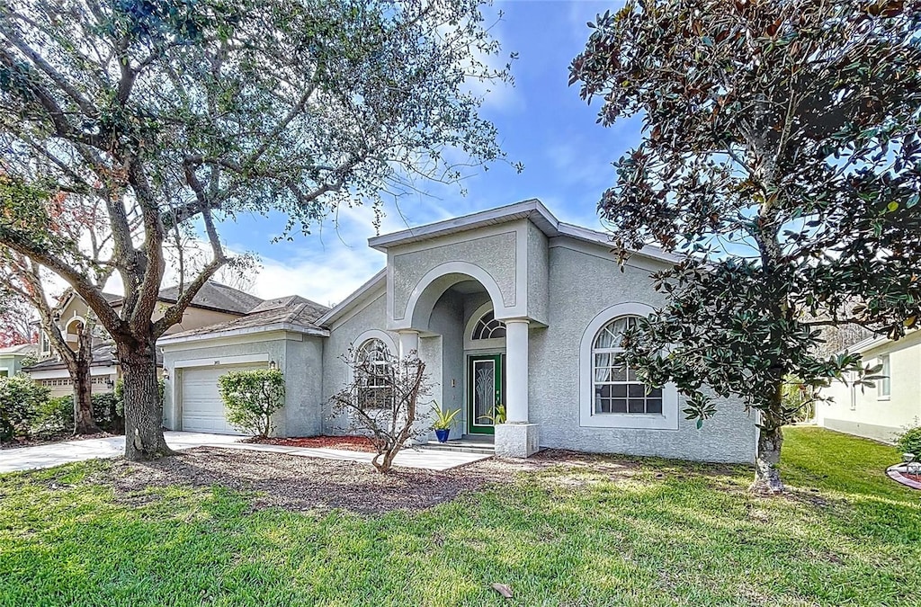 ranch-style home with a garage and a front lawn