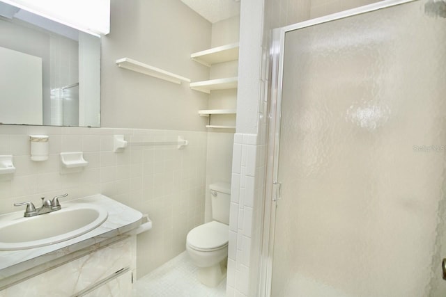 bathroom with vanity, toilet, tile walls, and an enclosed shower