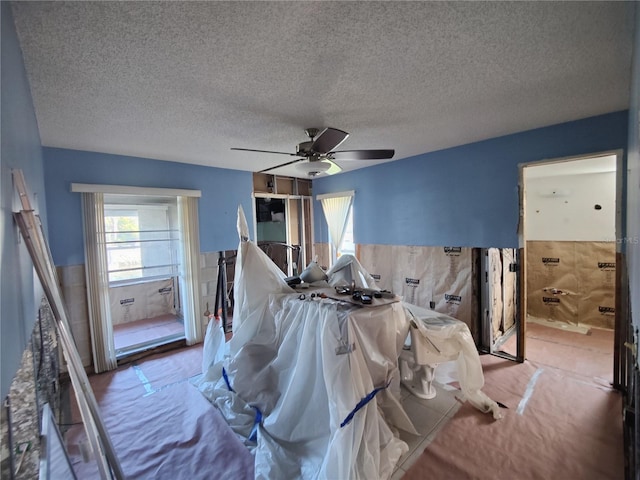 bedroom with ceiling fan and a textured ceiling