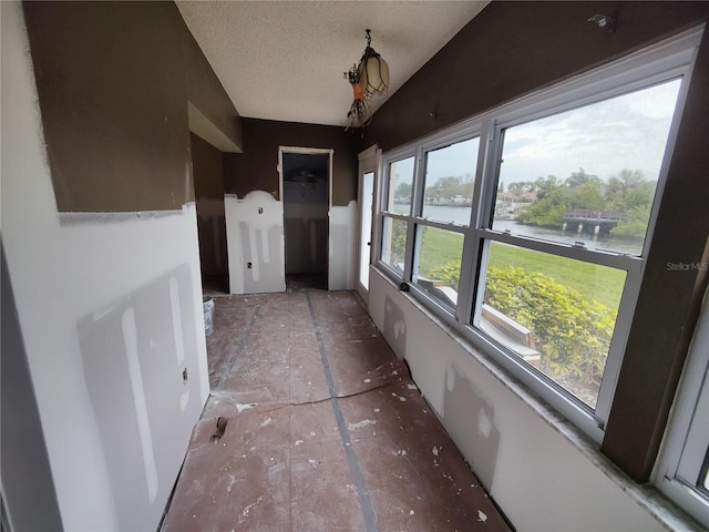 unfurnished sunroom featuring a water view