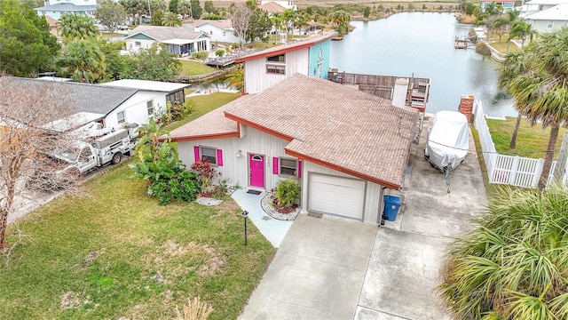 view of front of property featuring a garage, a front yard, and a water view