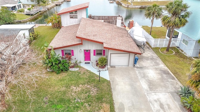 view of front facade featuring a water view, a garage, and a front lawn