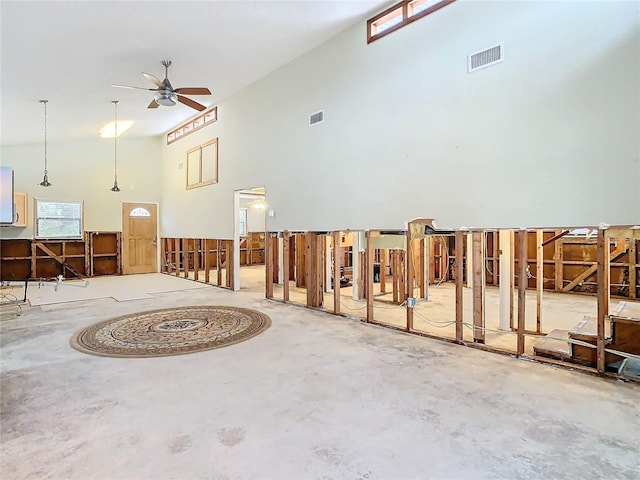 misc room with ceiling fan, concrete floors, and a towering ceiling