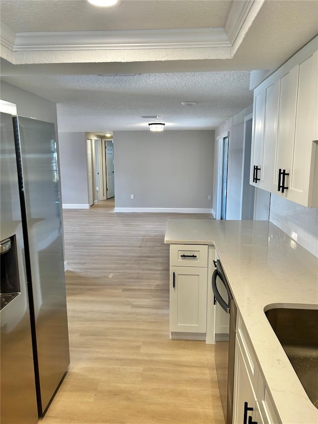 kitchen with a peninsula, light wood-style flooring, appliances with stainless steel finishes, and white cabinets