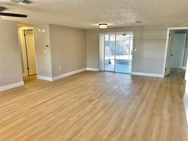 unfurnished room with light wood-style flooring, baseboards, and a textured ceiling