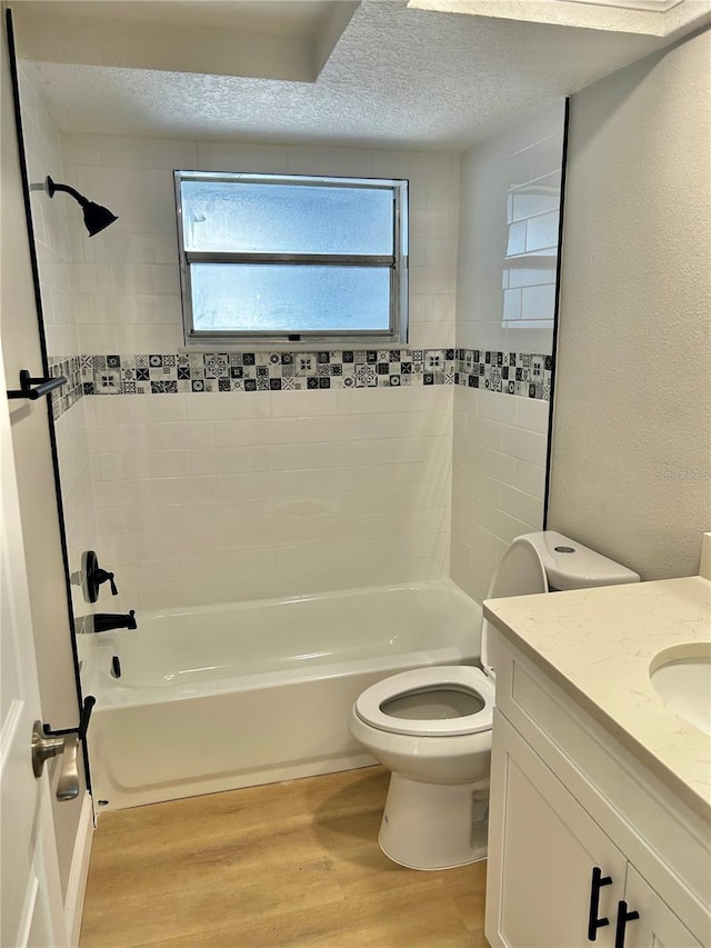 bathroom featuring a textured ceiling, toilet, wood finished floors, vanity, and bathing tub / shower combination