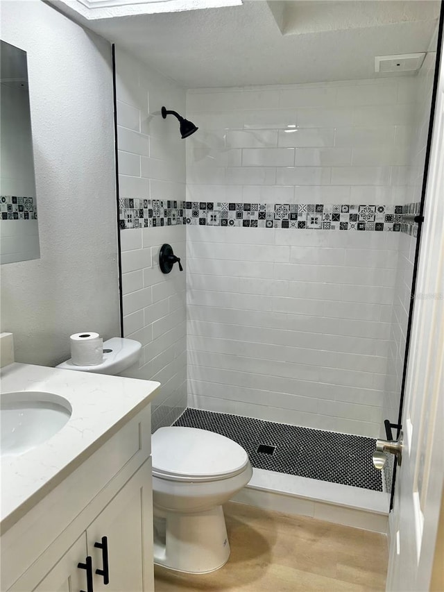 full bath featuring toilet, a shower stall, wood finished floors, and vanity