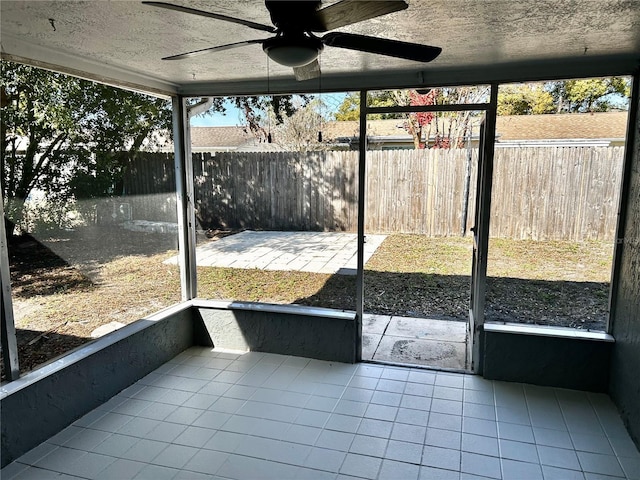 unfurnished sunroom featuring a wealth of natural light and ceiling fan