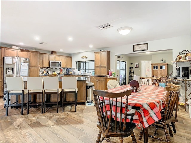 dining area with sink and light hardwood / wood-style floors