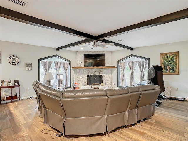 living room featuring light hardwood / wood-style floors, lofted ceiling with beams, ceiling fan, and a fireplace