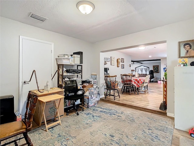 home office featuring hardwood / wood-style flooring and a textured ceiling