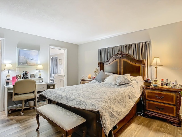 bedroom with light hardwood / wood-style flooring and ensuite bath