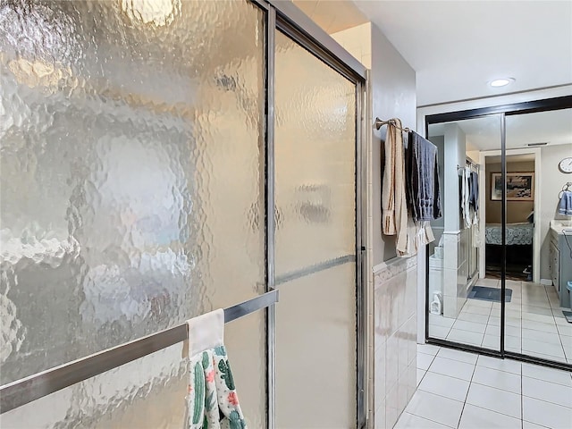 bathroom with tile walls, walk in shower, and tile patterned flooring