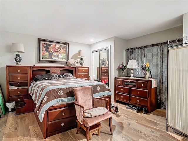 bedroom with light hardwood / wood-style floors and a closet