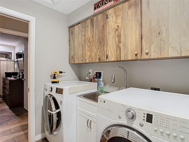 clothes washing area featuring wood-type flooring, independent washer and dryer, cabinets, and sink