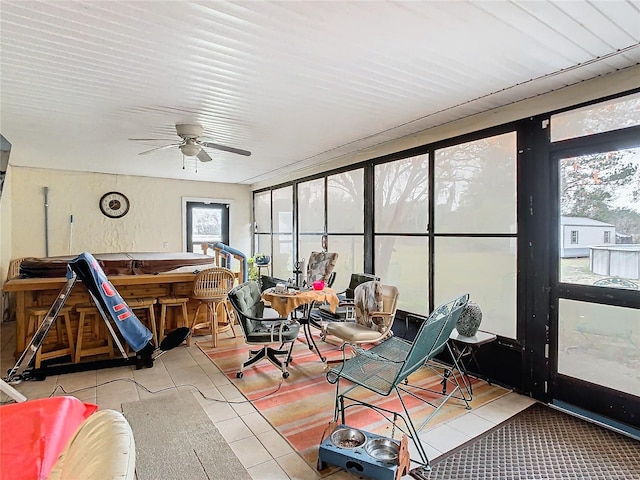 sunroom / solarium featuring ceiling fan