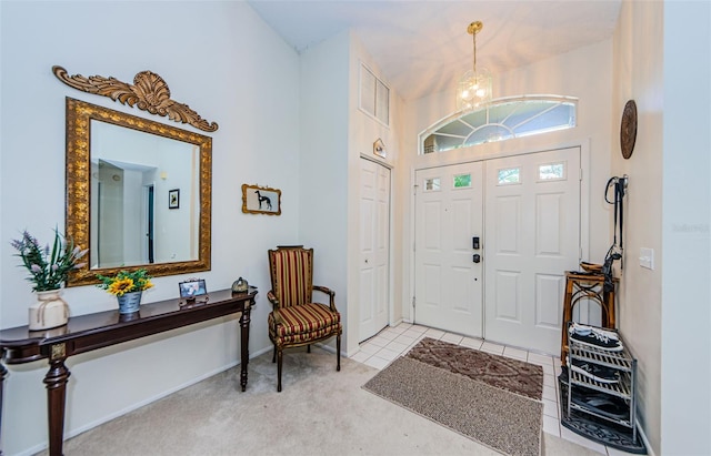 entryway featuring light colored carpet and an inviting chandelier