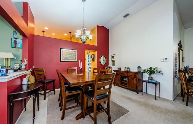 carpeted dining room with a notable chandelier and high vaulted ceiling